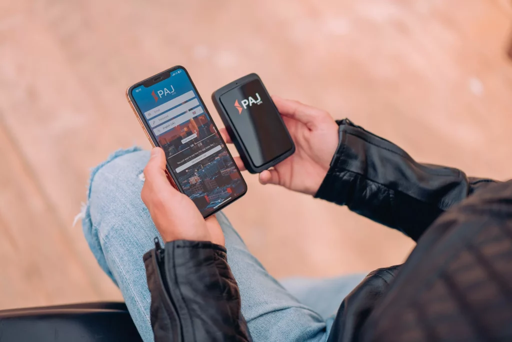 Motociclista con GPS tracker ALLROUND Finder e smartphone per la localizzazione